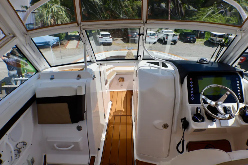 Slide: The Image of Interior view of 2023 Edgewater 262CX Crossover boat, featuring modern dashboard and seating. - 33