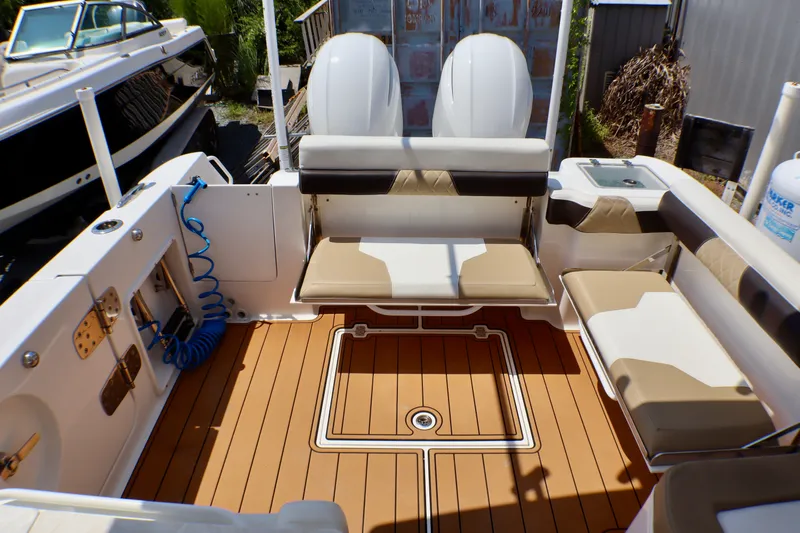 Slide: The Image of 2023 Edgewater 262CX Crossover boat interior with tan seating and teak-style flooring. - 22