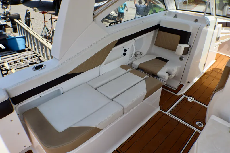 Slide: The Image of 2023 Edgewater 262CX Crossover boat interior with cushioned seating and teak-style flooring. - 24
