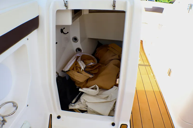 Slide: The Image of Storage compartment on 2023 Edgewater 262CX Crossover boat with gear inside. - 39