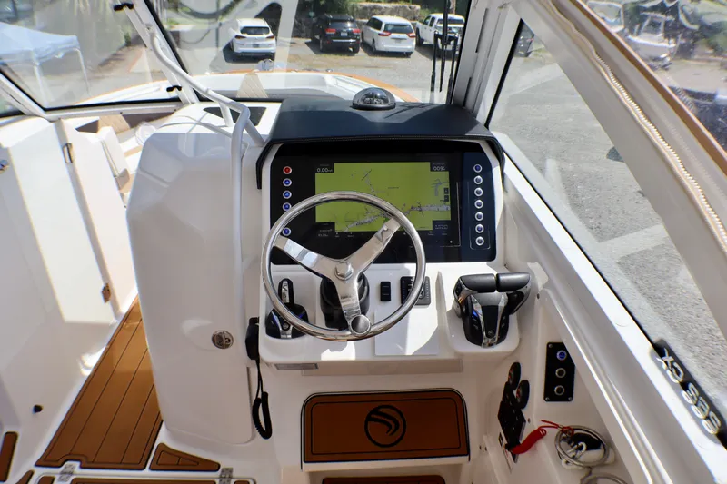 Slide: The Image of Edgewater 262CX Crossover 2023 boat cockpit with steering wheel and navigation display. - 28