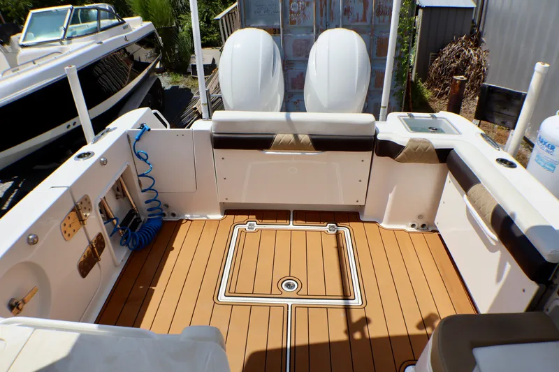 Slide: The Image of 2023 Edgewater 262CX Crossover boat interior with teak flooring and seating. - 21
