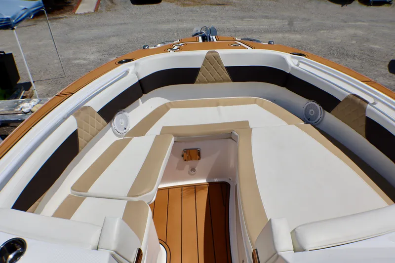 Slide: The Image of 2023 Edgewater 262CX Crossover boat interior with cushioned seating and speakers. - 34