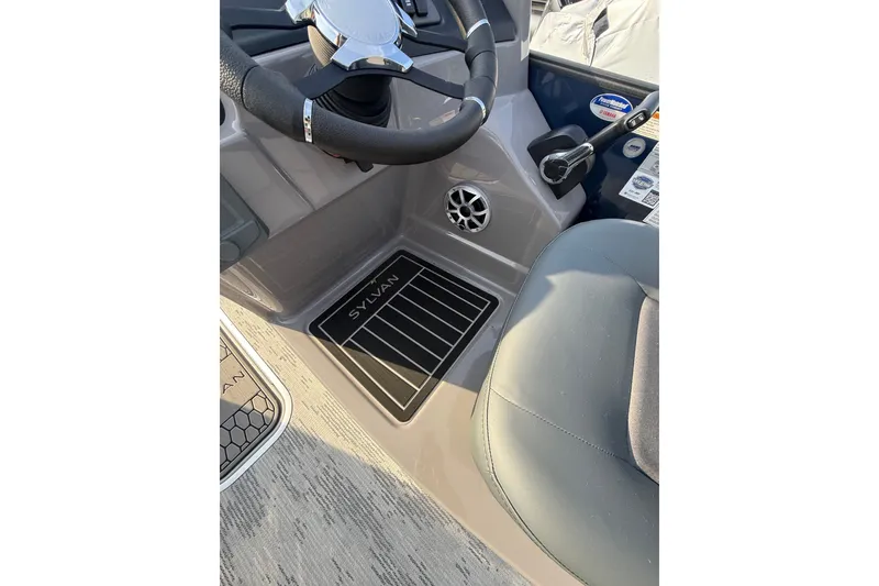 Slide: The Image of 2026 Sylvan L3 ULZ DH boat interior with steering wheel and branded floor mat. - 17