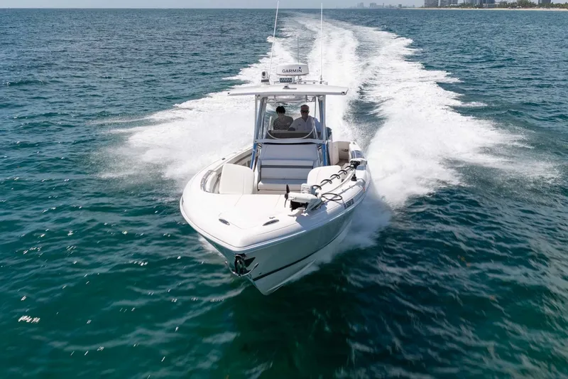 Slide: The Image of 2021 Intrepid 327 Nomad cruising on open water, showcasing sleek design and performance. - 8