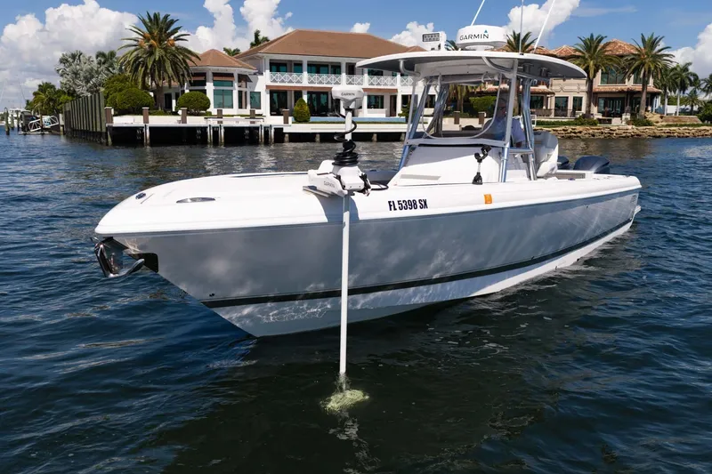 Slide: The Image of 2021 Intrepid 327 Nomad boat on water near luxury waterfront homes. - 14