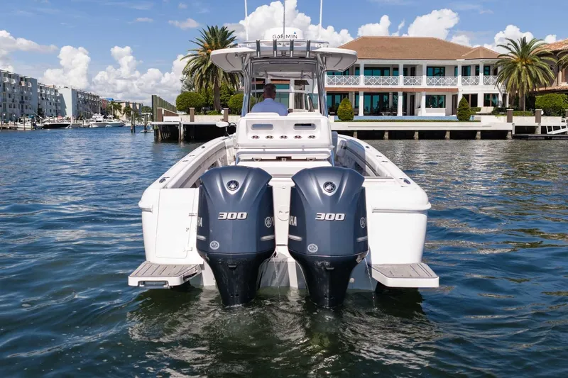 Slide: The Image of 2021 Intrepid 327 Nomad boat with twin Yamaha 300 engines on a sunny waterfront. - 9