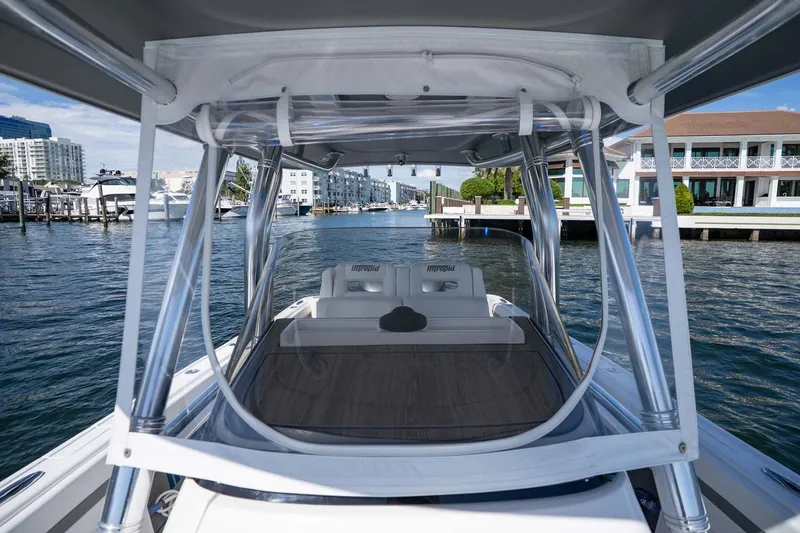 Slide: The Image of 2021 Intrepid 327 Nomad boat docked in a marina with waterfront buildings. - 36