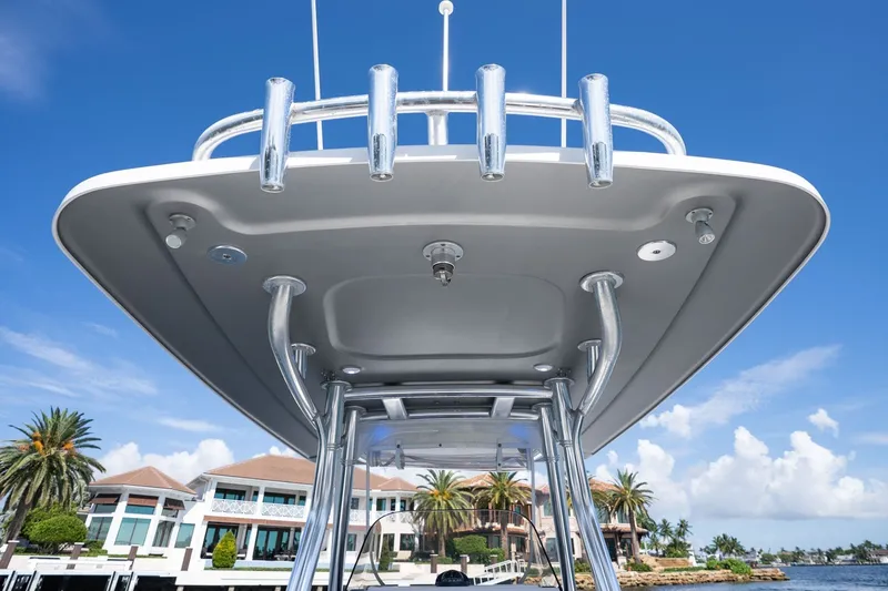 Slide: The Image of 2021 Intrepid 327 Nomad boat with sleek design, docked near waterfront homes. - 20