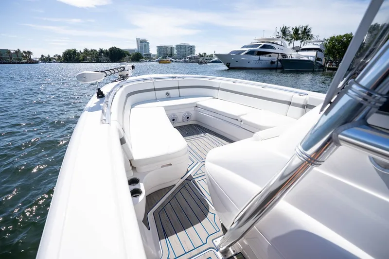 Slide: The Image of 2021 Intrepid 327 Nomad boat with spacious seating, docked in a sunny marina. - 32