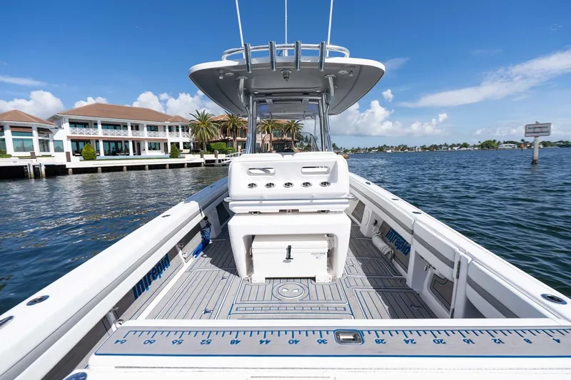 Slide: The Image of Intrepid 327 Nomad 2021 boat on water, showcasing spacious deck and modern design. - 18