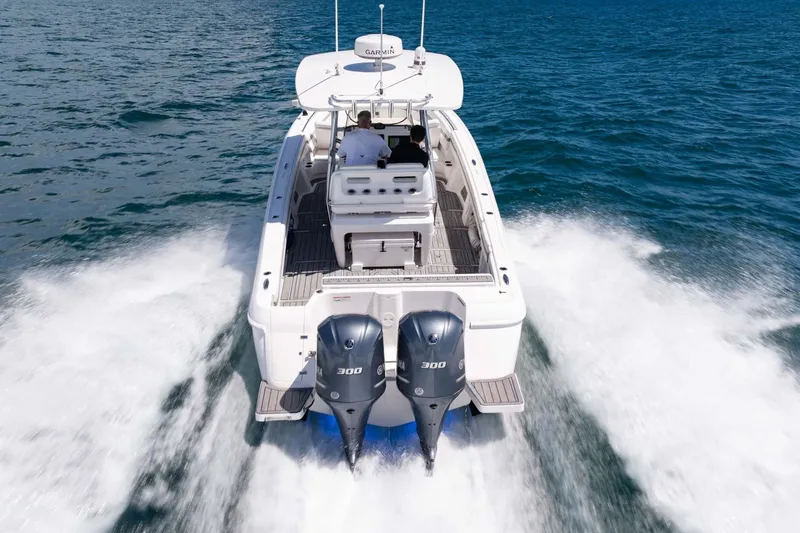 Slide: The Image of 2021 Intrepid 327 Nomad cruising on open water, showcasing powerful dual engines. - 4
