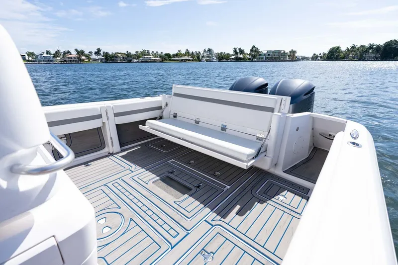 Slide: The Image of 2021 Intrepid 327 Nomad boat interior with seating, on a calm water backdrop. - 17
