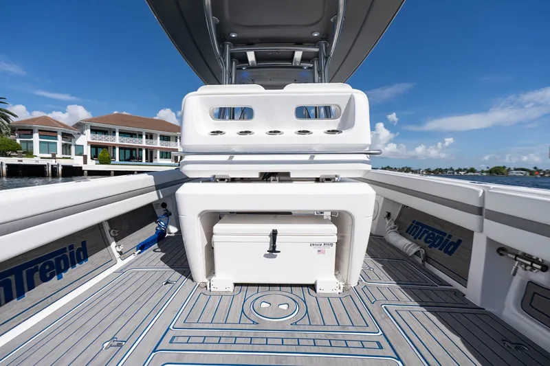 Slide: The Image of 2021 Intrepid 327 Nomad boat interior with seating and storage, dockside view. - 19