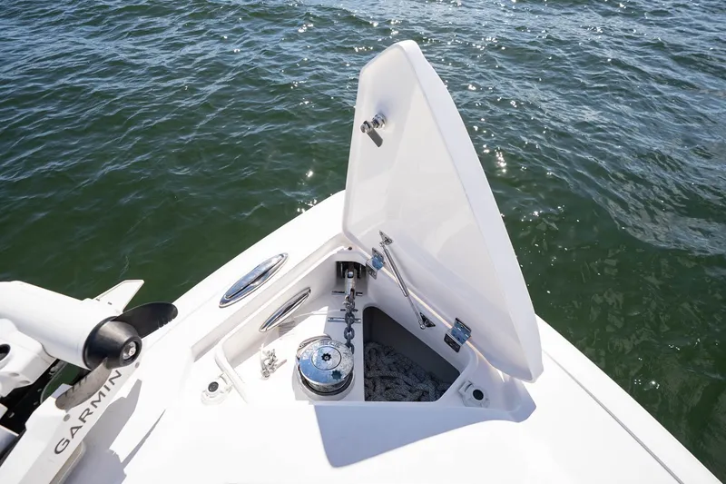 Slide: The Image of Open anchor compartment on 2021 Intrepid 327 Nomad boat, with visible water background. - 34