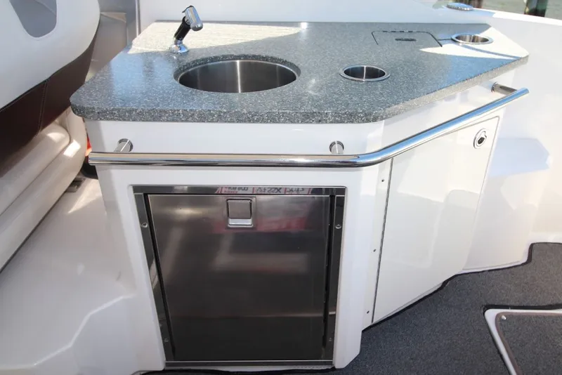 Slide: The Image of 2012 Chaparral 327 SSX boat kitchenette with sink and stainless steel fridge. - 14