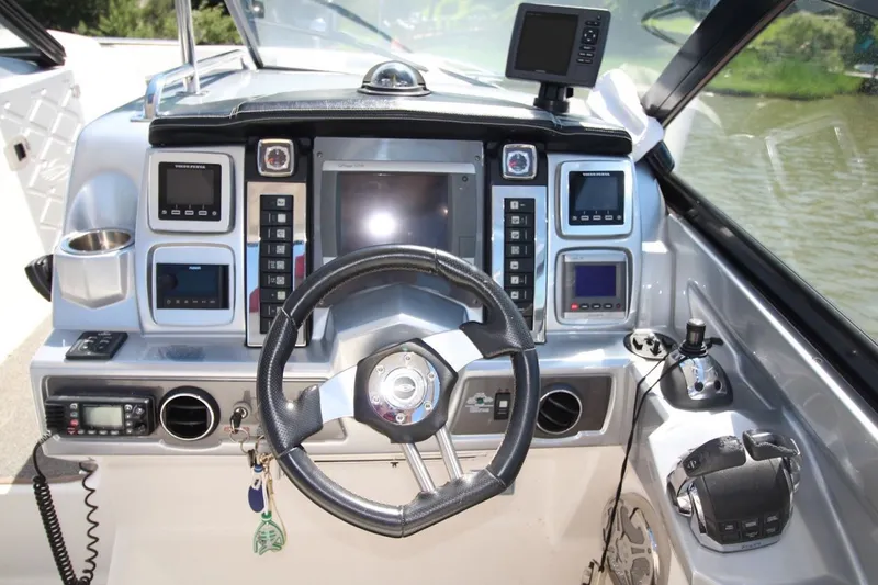 Slide: The Image of Cockpit of 2012 Chaparral 327 SSX boat with advanced navigation controls and steering wheel. - 18