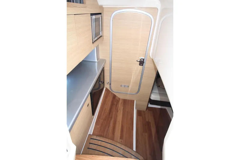 Slide: The Image of Interior of 2012 Chaparral 327 SSX boat with wood flooring and compact kitchenette. - 21