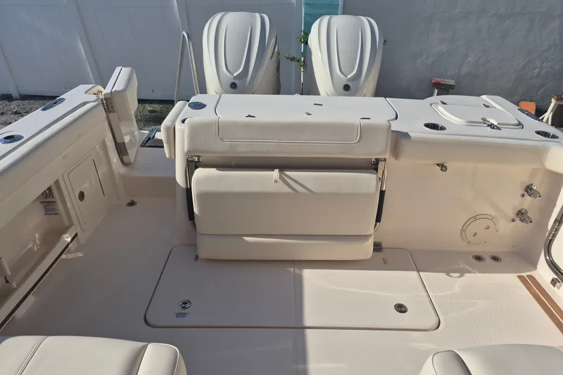 Slide: The Image of 2027 Grady-White Freedom 307 boat interior with dual outboard motors and seating area. - 19
