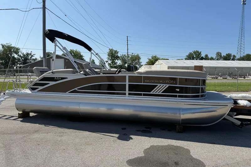 The Image of 2027 Bennington 23 MSL pontoon boat parked outdoors on a sunny day. - 0