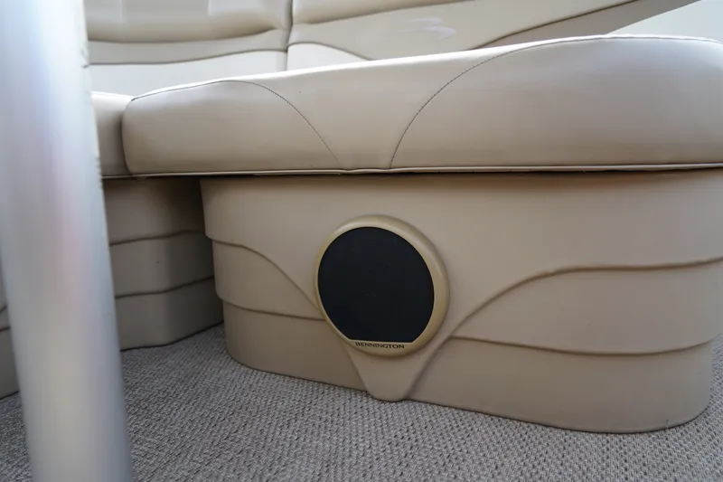 Slide: The Image of 2018 Bennington 22 SSX boat interior with beige seating and integrated speaker. - 23