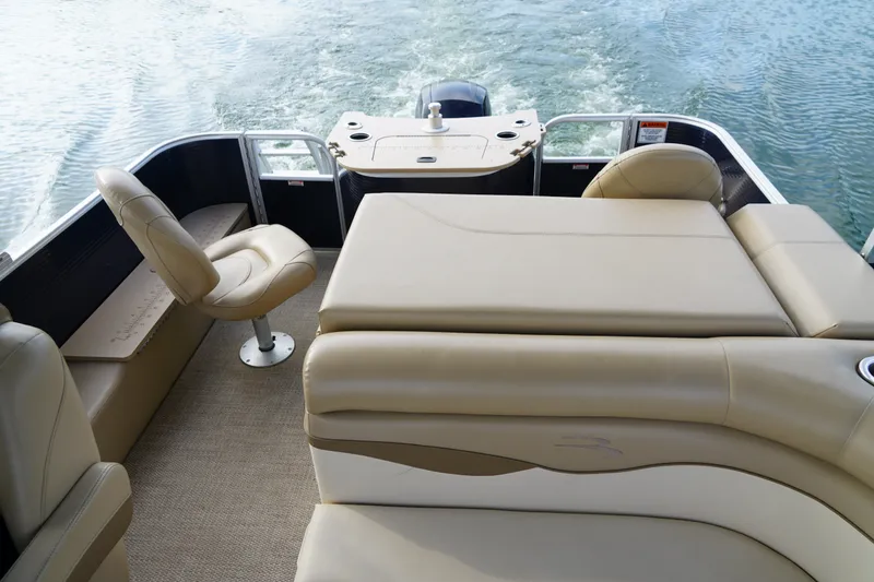 Slide: The Image of 2018 Bennington 22 SSX boat interior with beige seating and water view. - 12