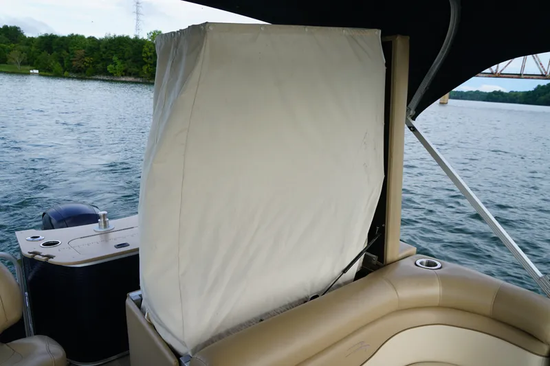 Slide: The Image of 2018 Bennington 22 SSX boat interior with covered seating, on a scenic lake. - 22