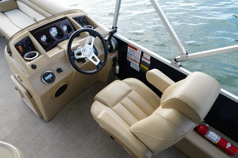 Slide: The Image of 2018 Bennington 22 SSX boat helm with beige captain's chair and steering wheel. - 16