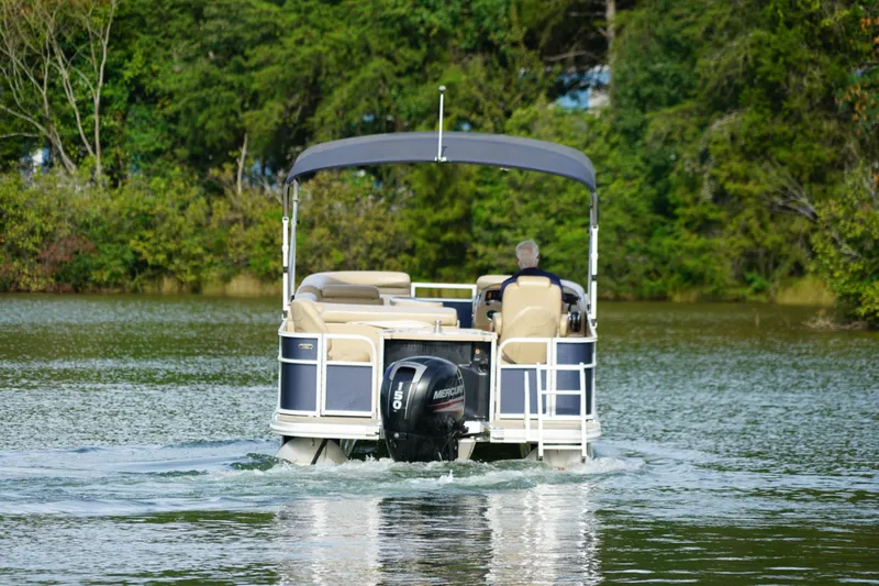 Slide: The Image of 2018 Bennington 22 SSX pontoon boat cruising on a serene lake. - 7