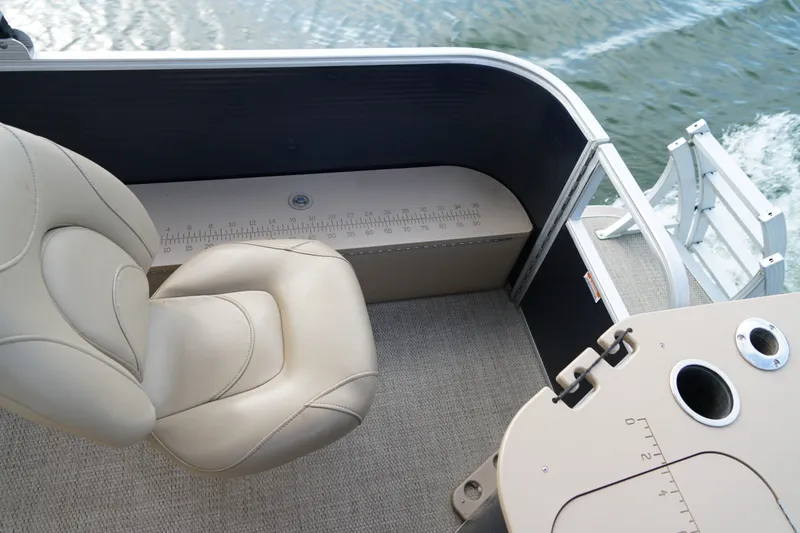 Slide: The Image of 2018 Bennington 22 SSX boat interior with beige seating and measuring ruler. - 11