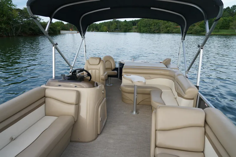 Slide: The Image of 2018 Bennington 22 SSX pontoon boat with beige seating on a serene lake. - 20