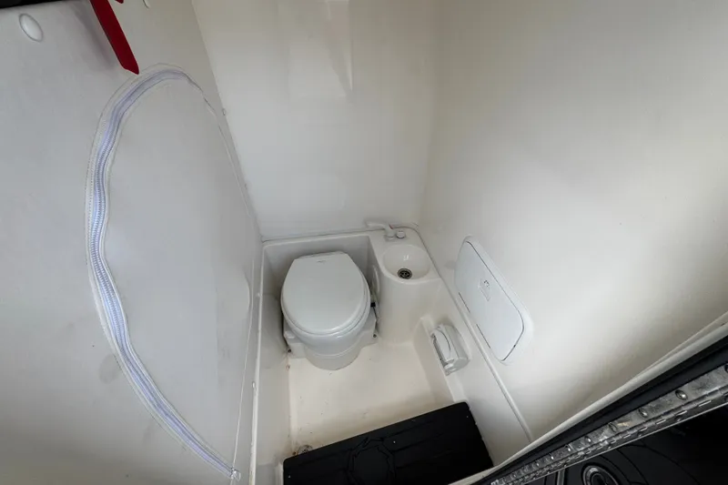 Slide: The Image of Compact bathroom in 2024 Fountain 34 Tournament Edition boat, featuring a toilet and sink. - 15