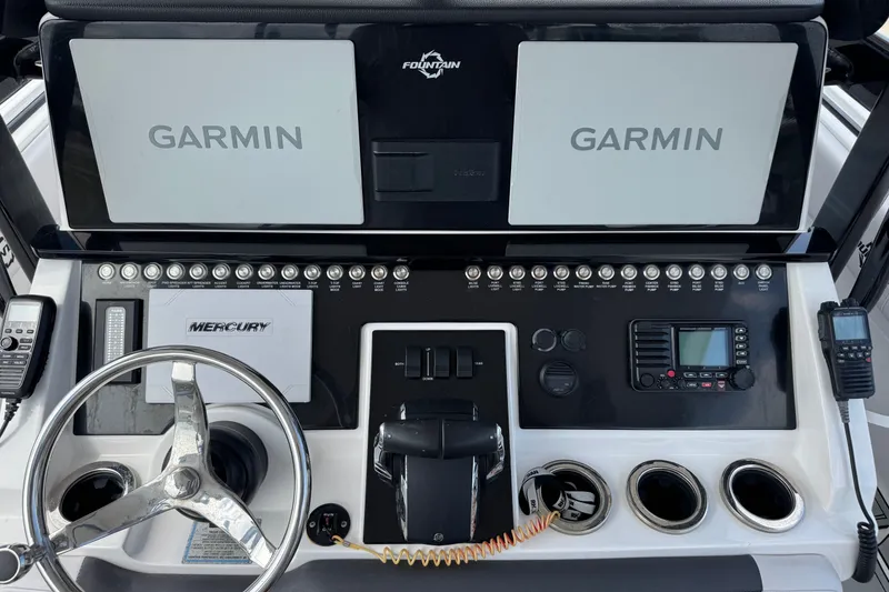 Slide: The Image of 2024 Fountain 34 Tournament Edition boat dashboard with Garmin displays and Mercury controls. - 18