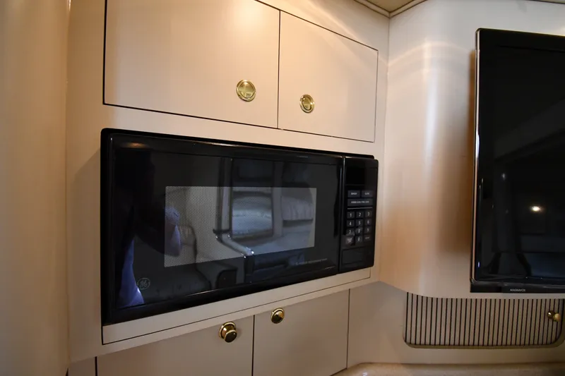 Slide: The Image of Microwave and cabinetry inside a 2000 Sea Ray 330 Express Cruiser yacht. - 29