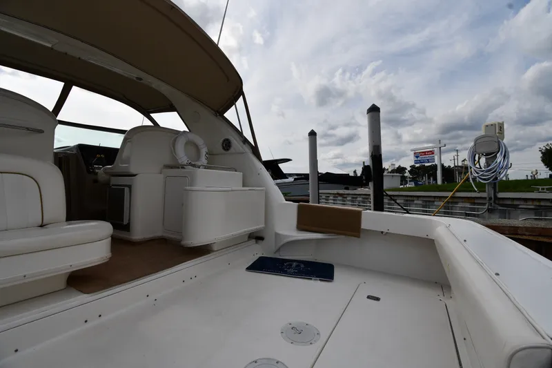 Slide: The Image of 2000 Sea Ray 330 Express Cruiser docked, featuring spacious seating and overcast sky. - 15