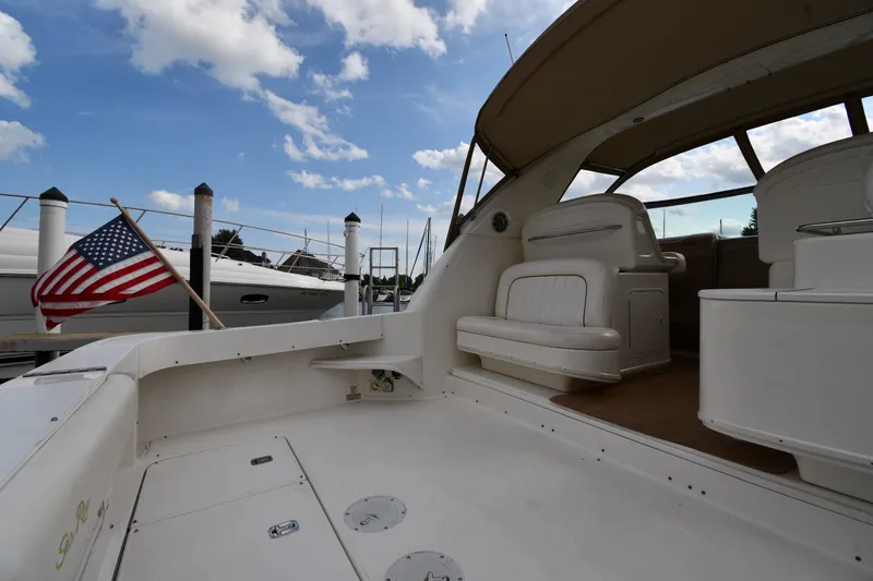 Slide: The Image of 2000 Sea Ray 330 Express Cruiser interior with American flag, docked under blue sky. - 16