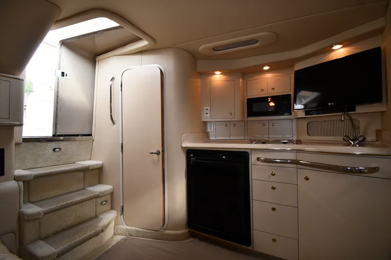 Slide: The Image of Interior of 2000 Sea Ray 330 Express Cruiser with kitchenette and stairs. - 21