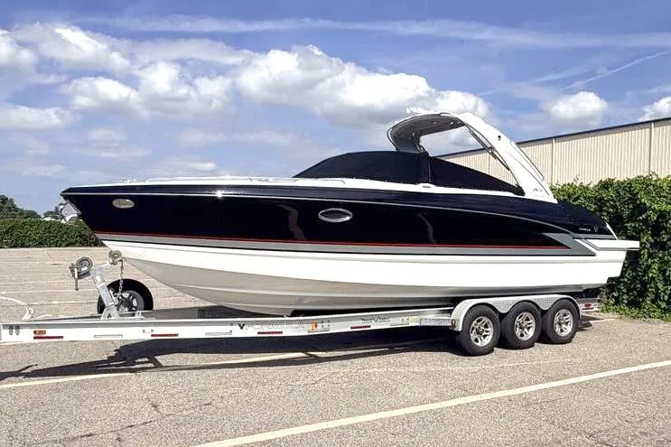 Slide: The Image of 2018 Formula 290 Sun Sport boat on a trailer, parked outdoors under a clear sky. - 2