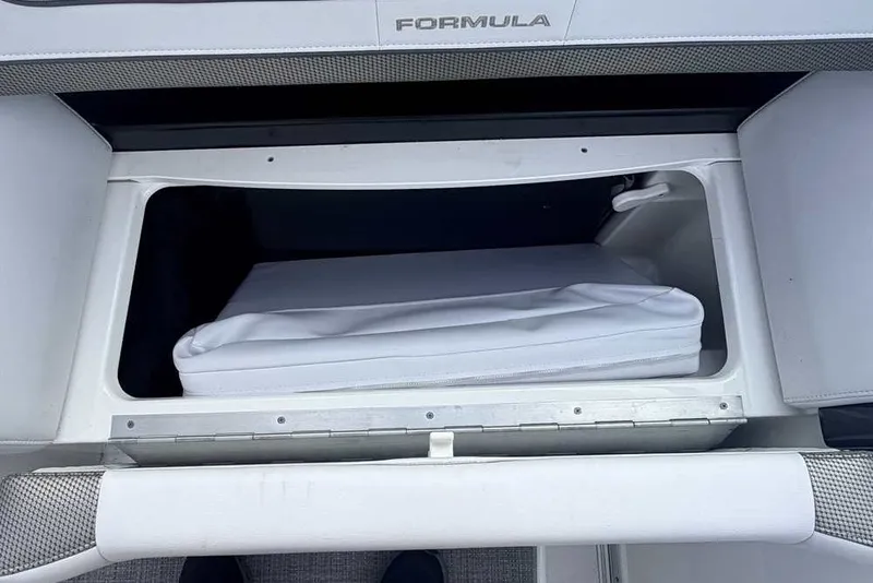 Slide: The Image of Storage compartment in a 2018 Formula 290 Sun Sport boat, featuring a white cushion. - 26