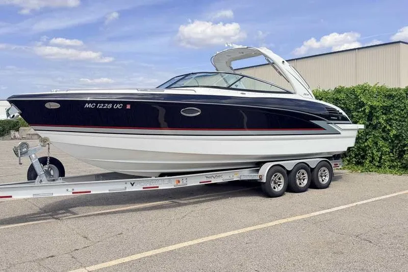 The Image of 2018 Formula 290 Sun Sport boat on a trailer, parked outdoors under a blue sky. - 0
