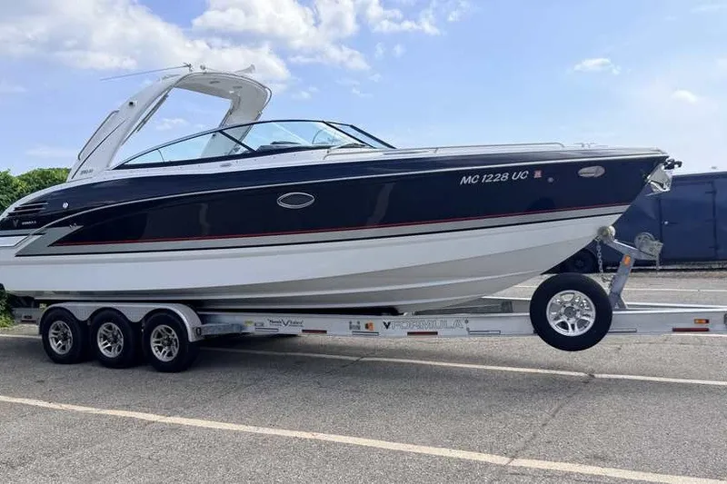 Slide: The Image of 2018 Formula 290 Sun Sport boat on trailer, parked outdoors under a clear sky. - 1