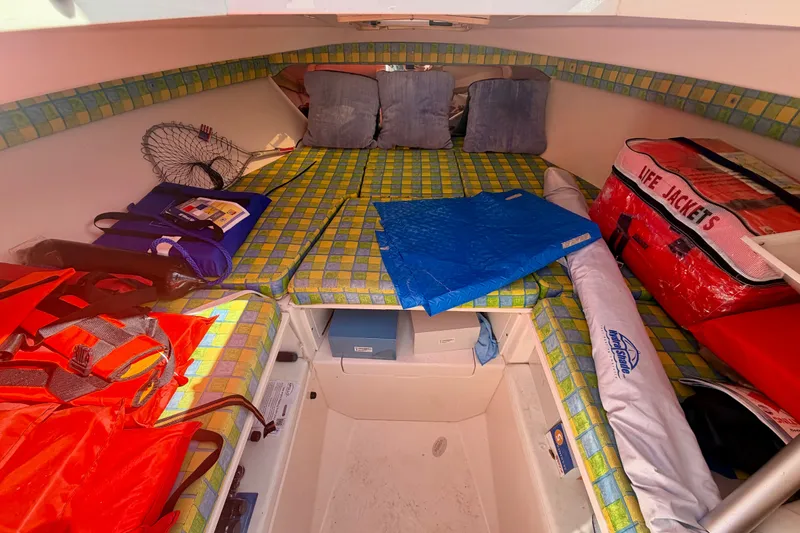 Slide: The Image of Cuddy cabin interior of 2001 Intrepid 322, featuring life jackets and colorful cushions. - 9