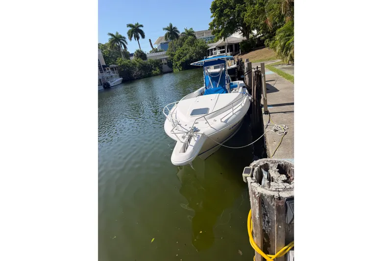Slide: The Image of 2001 Intrepid 322 Cuddy boat docked on a calm, tree-lined waterway. - 7