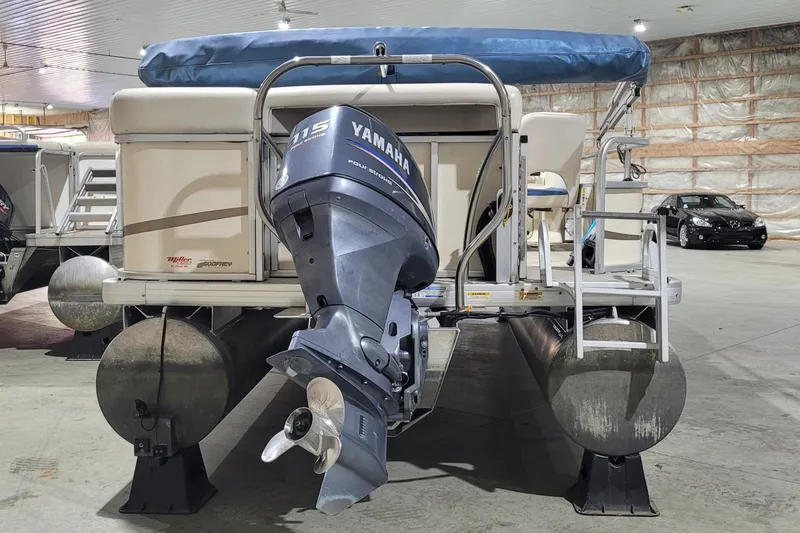 The Image of 2006 Sweetwater 2386RE pontoon boat with Yamaha 115 outboard motor in storage facility. - 2