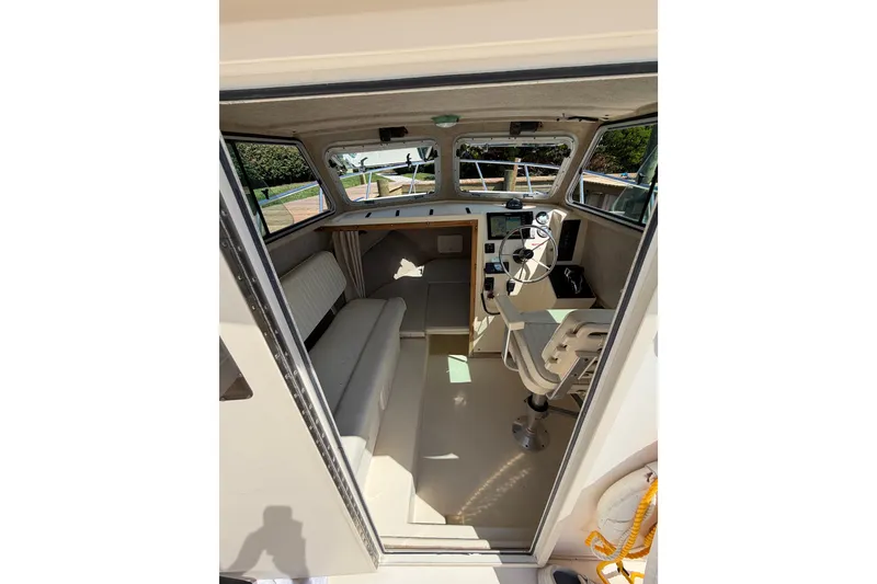 Slide: The Image of Interior of a 2005 Parker 2520 Modified Vee Sport Cabin boat, featuring helm and seating. - 18