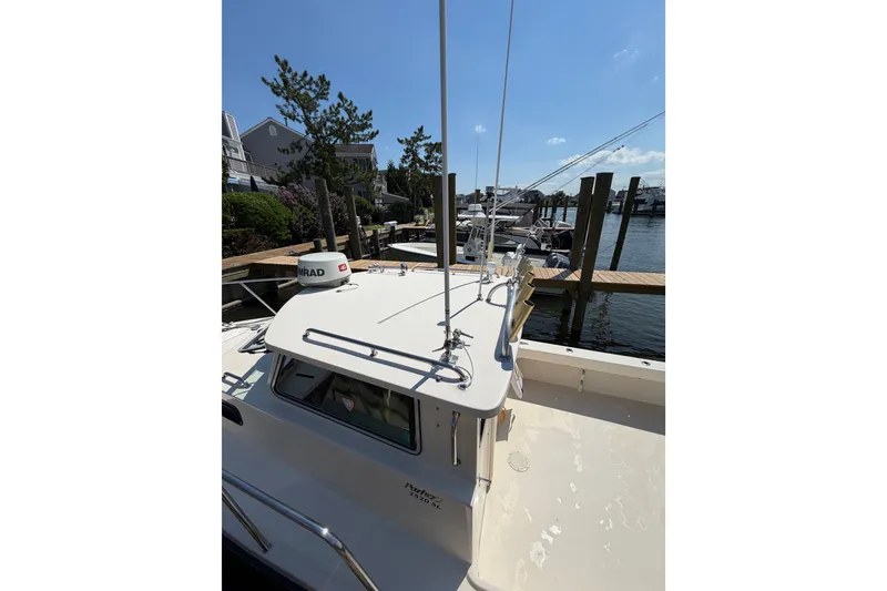 Slide: The Image of 2005 Parker 2520 Modified Vee Sport Cabin boat docked at marina under clear sky. - 29