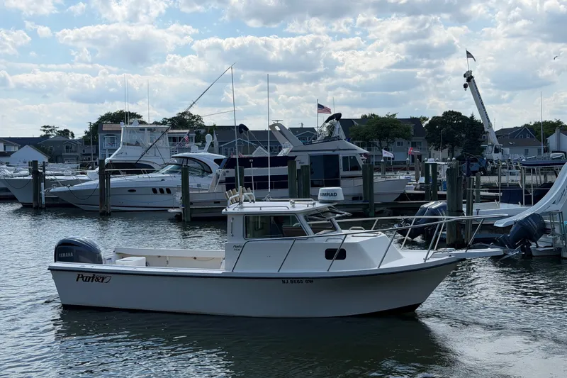 The Image of 2005 Parker 2520 Modified Vee Sport Cabin boat docked in a marina. - 0