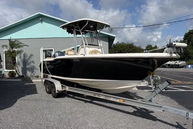 Slide: The Image of 2017 Key West 239 FS boat on trailer, parked outside a building under a cloudy sky. - 2