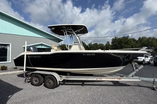 Slide: The Image of 2017 Key West 239 FS boat on trailer, parked outdoors under a cloudy sky. - 3