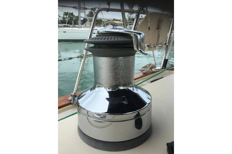 Slide: The Image of Chrome winch on 2006 Island Packet 440 sailboat deck, with marina background. - 49